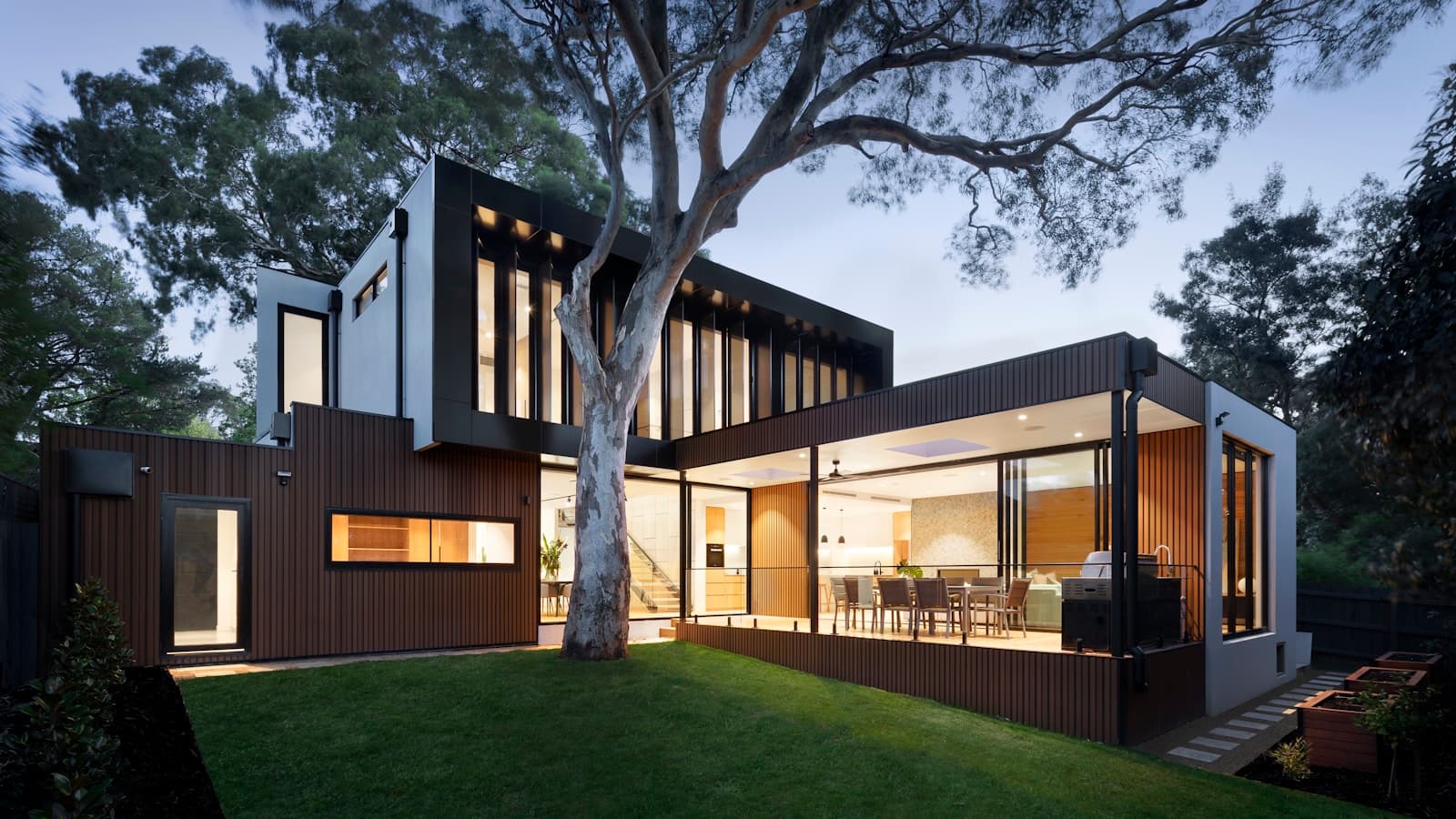 Modern passive house with large windows surrounded by nature